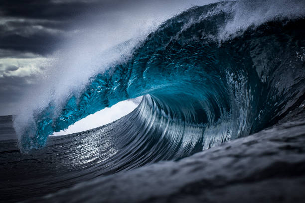 istock Strong ocean wave breaking in front of dark clouds 1392793419