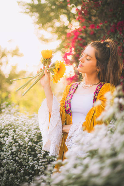 istock Woman enjoying garden while smelling sunflower 1392794270