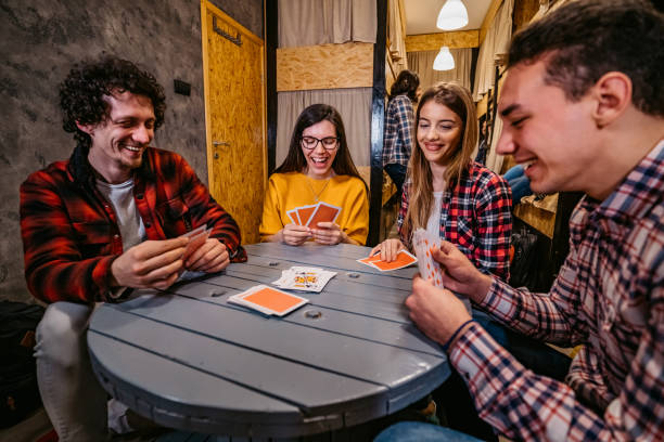 istock Young people playing cards in hostel 1392794333