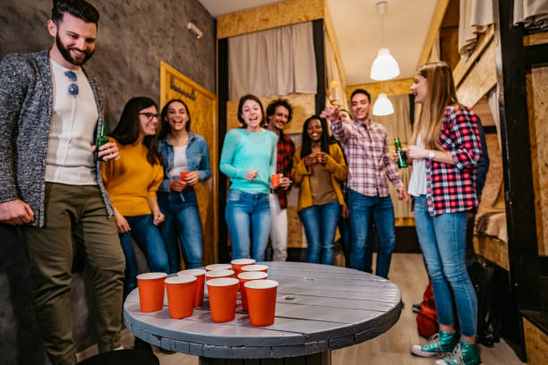 istock Young people playing beer pong in hostel 1392794454