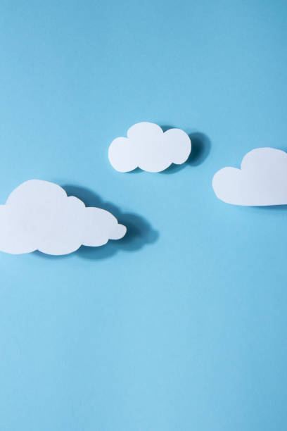 istock Paperart. White clouds on a bright blue background 1392794498
