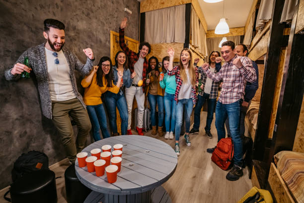 istock Young people playing beer pong in hostel 1392794536