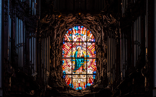 ancient beautiful musical organ and a stained-glass Gothic window with the image of the Virgin Mary. Interior of the Catholic Cathedral in Oliwa, Gdansk