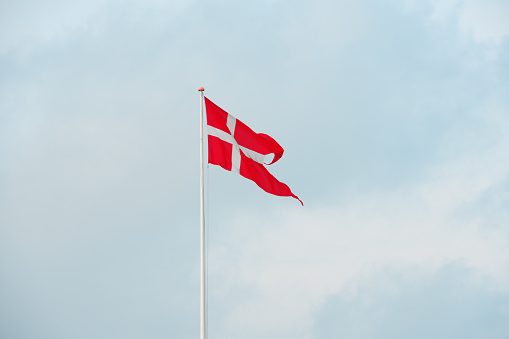 Danish flag is waving on sky background