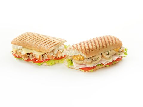 Two Italian sandwich (panini). One of them stuffed with tomato, lettuce, grilled chicken, gouda cheese, parmesan cheese and mayonnaise. The other stuffed with lettuce, tomato, turkey ham, gouda cheese, mushroom and mustard.