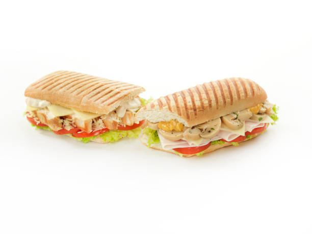 Panini Two Italian sandwich (panini). One of them stuffed with tomato, lettuce, grilled chicken, gouda cheese, parmesan cheese and mayonnaise. The other stuffed with lettuce, tomato, turkey ham, gouda cheese, mushroom and mustard. panino stock pictures, royalty-free photos & images