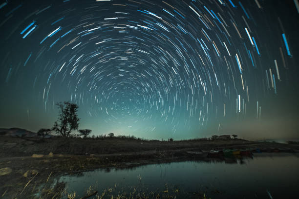 круговые звездные тропы над озером - время lapse стоковые фото и изображения