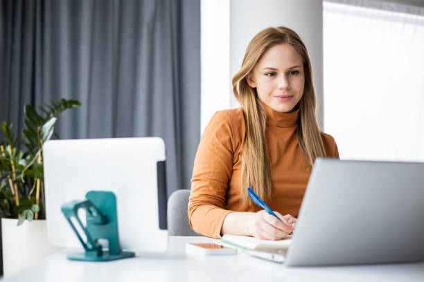 jovem se concentrando enquanto trabalhava - businesswoman using computer computer monitor women - fotografias e filmes do acervo