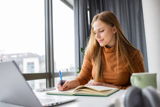 istock Young woman studying in her home office 1392800998