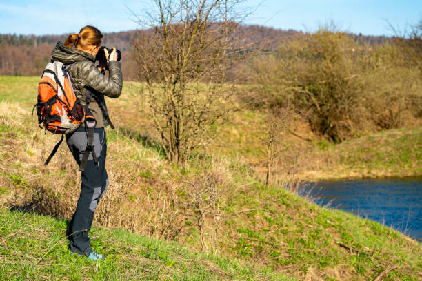 mulher curtindo, fotografando o despertar da primavera da natureza perto do lago planinsko polje, eslovênia - planinsko polje - fotografias e filmes do acervo