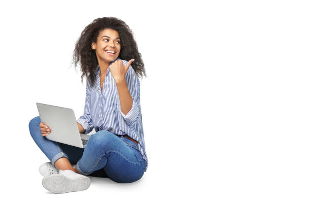 ritratto di una bella donna africana con il computer portatile isolato su priorità bassa bianca - sitting up foto e immagini stock