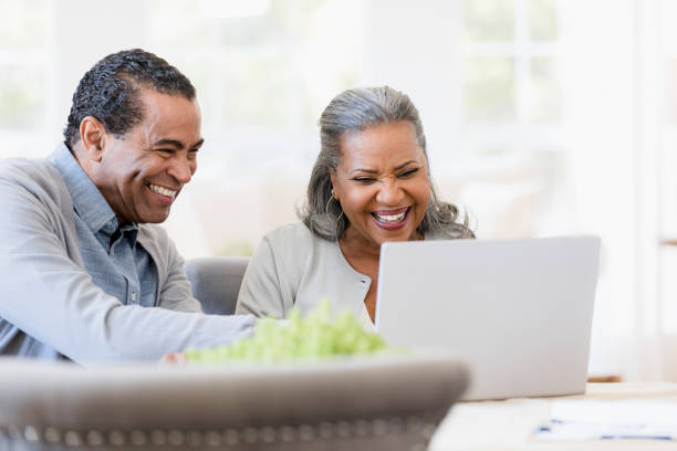 istock Senior couple enjoys looking through photos on laptop 1392802390