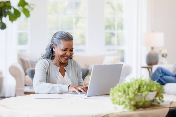 istock Husband relaxes while wife connects with family on laptop 1392802401