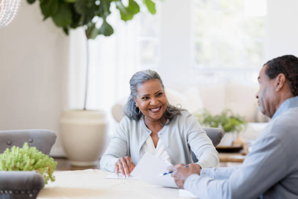 istock Going over home finances, cheerful senior woman smiles at husband 1392802403
