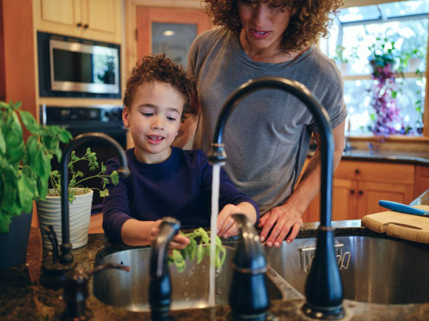istock Mother and Son Preparing Herbs from a Garden 1392804011