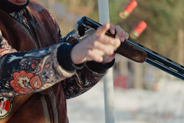 istock Hunter in camouflage with rifle in winter forest. Hunt concept. Man securing a reserve, on a snowy day. Hunter takes aim from a gun in the snowy forest 1392804067