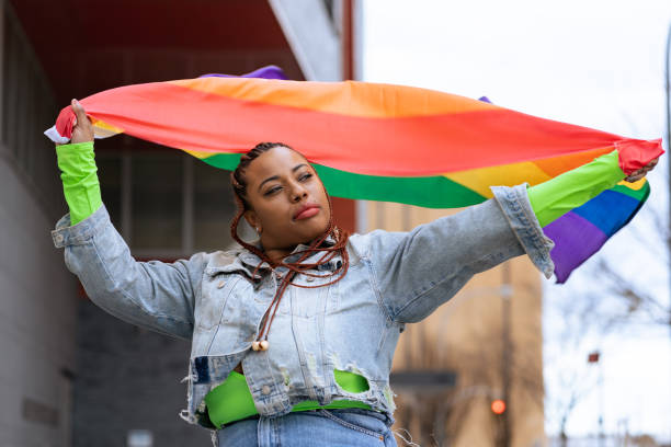 istock Confident black woman outdoors holding a rainbow flag 1392804899