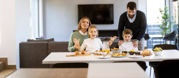 istock Young happy family talking while having breakfast at dining table 1392805382