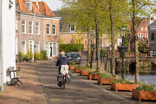 Amersfoort, Netherlands, April 21, 2022; An elderly man cycles with his groceries on the back of his bicycle, through the center of the city of Amersfoort.