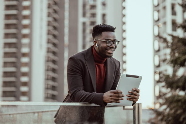 istock Smiling young businessman using digital tablet and checking online informations 1392808020