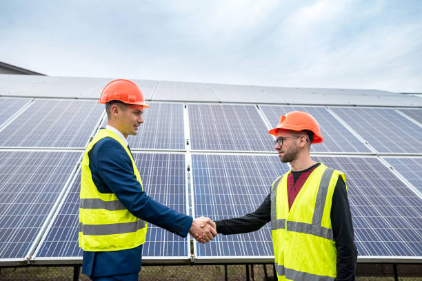 istock workers in  helmets two men shake hands after working on the installation of panels. 1392808312
