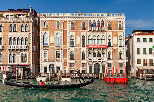 View of Palazzo Ca 'Giustinian on the Grand Canal in Venice, Italy. The head office of La Biennale di Venezia with a gondolier on gondola.