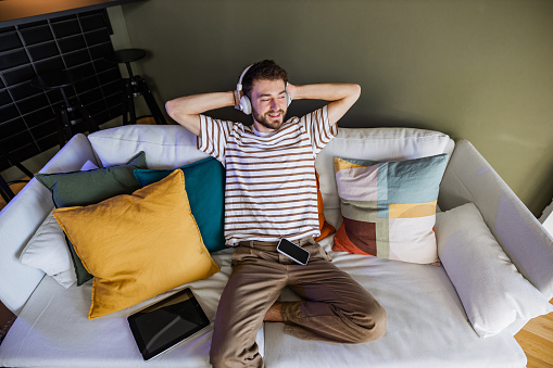 Young man enjoying at home and listening to music