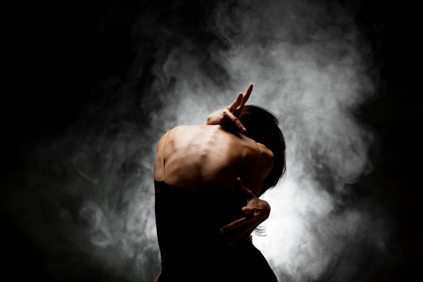 istock half silhouette modern ballet dancer posing on dark background with smoke 1392819673