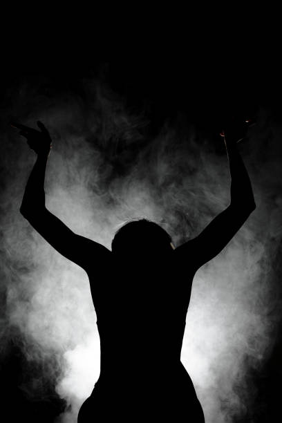 istock silhouette modern ballet dancer posing on dark background with smoke 1392819676