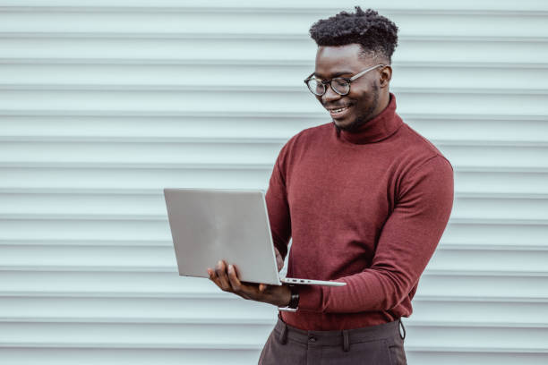istock African-American elegant man using laptop outdoors 1392828384