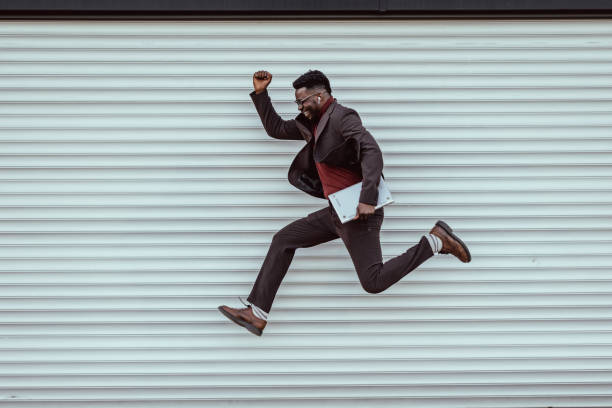 istock Happy young businessman jumping 1392828574