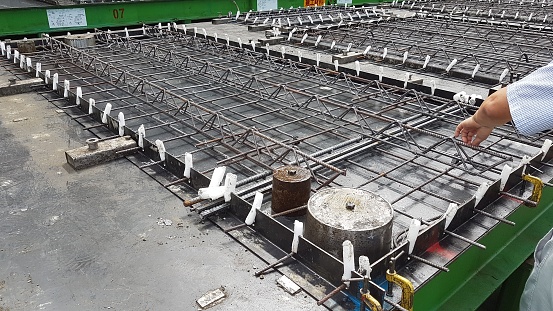 Precast concrete girder slab on a pallet with reinforcement and installation parts in a precast concrete plant ready for production