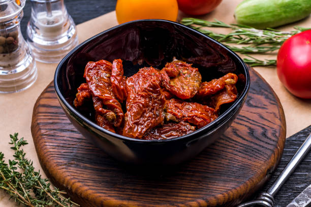istock sun-dried tomatoes on black plate macro closeup 1392829604