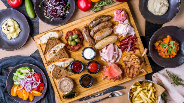 istock assorted sausages with sauces, sliced different meat, pastrami, parma ham, rack of lamb, mashed celery, french fries, mashed potatoes, vegetable salad and beetroot salad with cheese top view food 1392830223