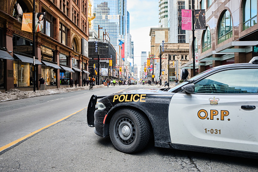 Here is a street in downtown Toronto city that's blocked by a police car. Authorities and officers are controlling Covid-19 protestors.