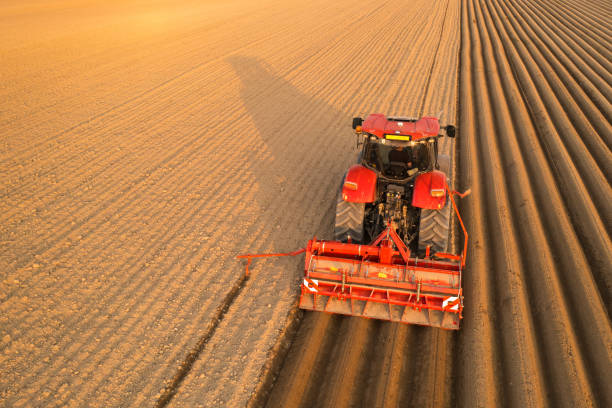 istock Tractor drags plow for leaving long furrows behind in soil 1392833825