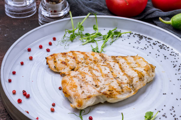 istock Fried chicken breast on grey plate on dark stone table macro close up 1392833830