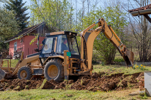 istock An excavator digging soil in a village in a private yard. 1392835673