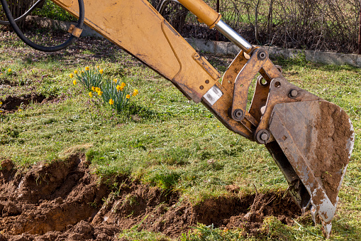 An bucket excavator in the village paves the way, digs soil and clears land.