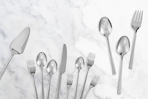 Kitchen flatware cutlery set on a white marble background