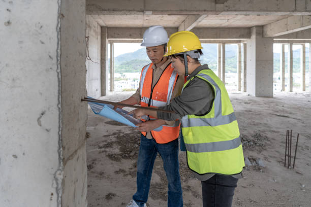istock Male and female construction workers inspect work in unfinished buildings 1392838231