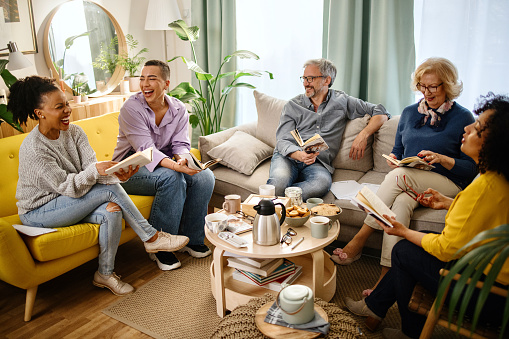 Small group of people with a mixed age range talking during a book club meeting.