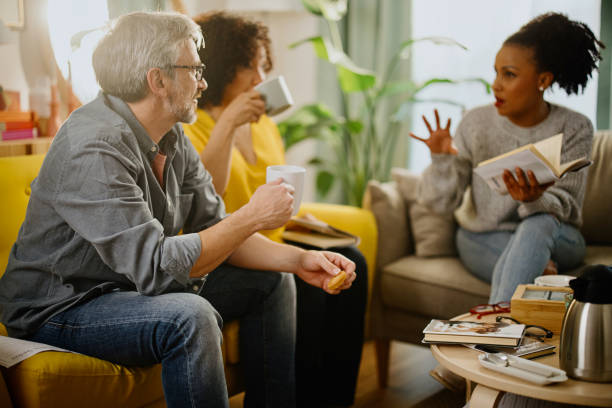 istock Diverse group of friends discussing a book 1392841249