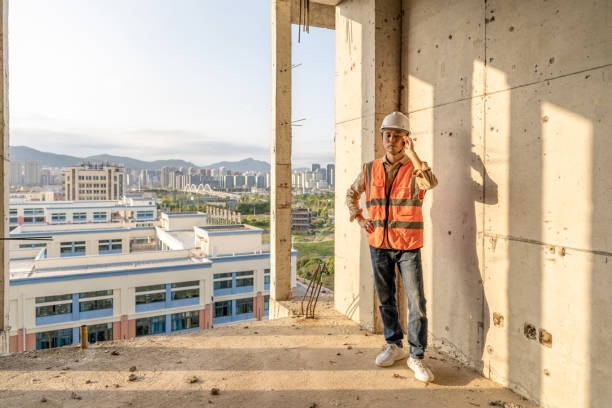 istock Male construction workers communicate with mobile phones on rough walls 1392841318