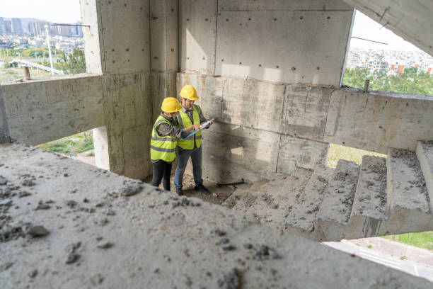 istock Male and female construction engineers check the project quality in uncompleted buildings 1392842098