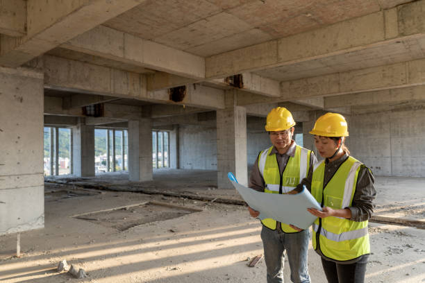 istock Male and female construction engineers with drawings comparing data 1392842100