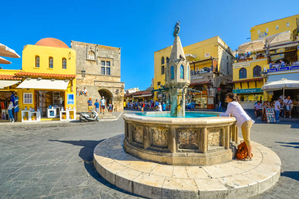 una turista se lava las manos en la fuente castellania en hipócrates o en la plaza ippokratous en el centro histórico de rodas en la isla de rodas, grecia. - wash stand fotografías e imágenes de stock