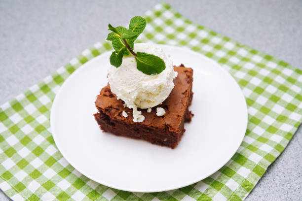 brownie portion with a ball of vanilla ice-cream on top. American traditional pastry. Cocoa powder and chocolate are main ingredients. stock photo