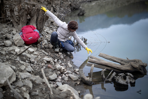 Mi Adult Female Environmentalist Taking Sample of Water Outdoors