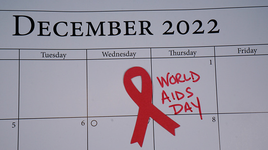 World AIDS Day written on a calendar on December 1, 2022 along with a red ribbon.